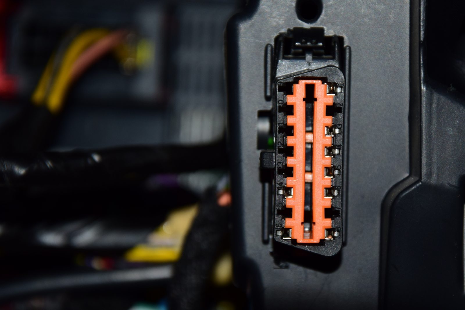 Photograph of a female OBD-II diagnostic connector fitted in a car footwell